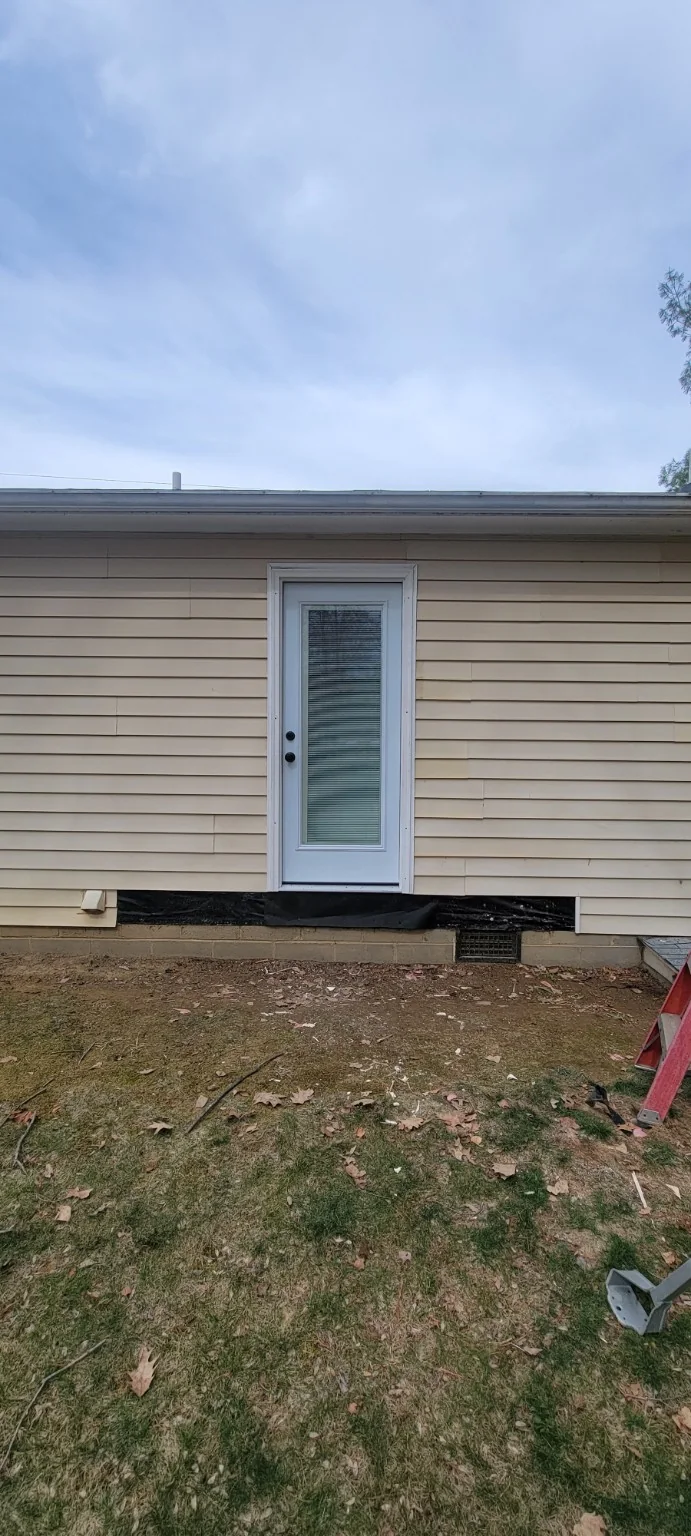 Exterior view of new full-glass door installed where a window had been